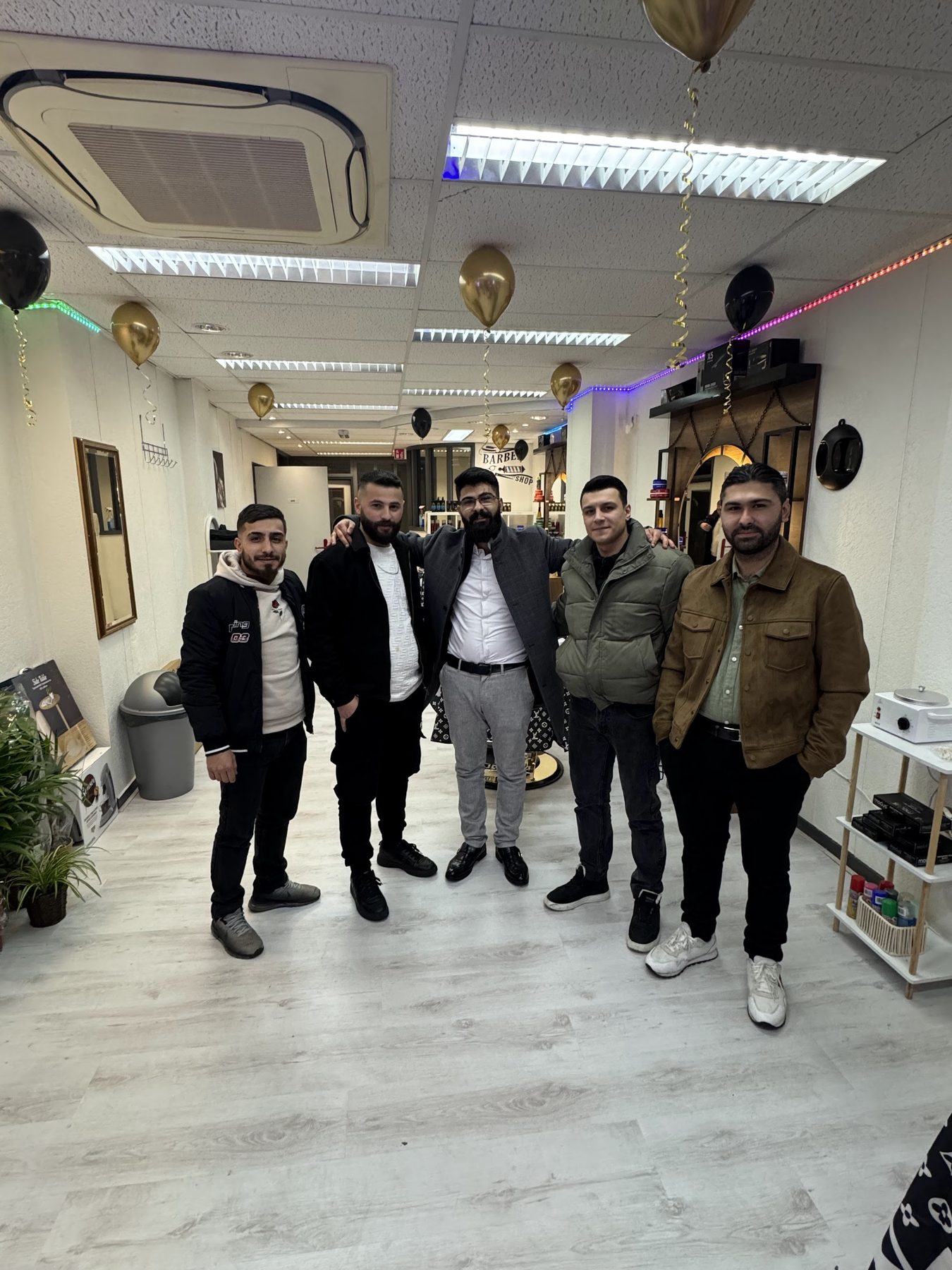 Het team van Barbershop Omar, vijf mannen naast elkaar in de zaak