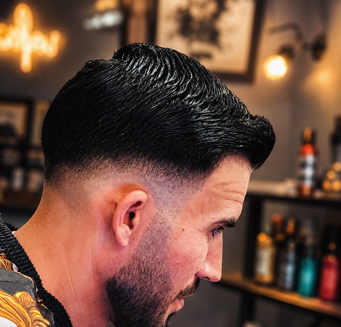 Strakke skin fade met de BARBER-neon van de zaak op de achtergrond