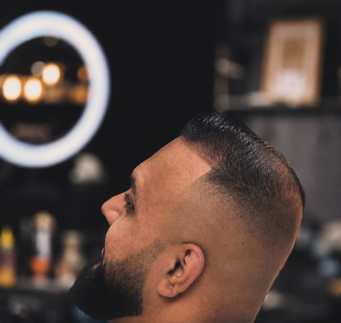 Skin fade met volle baard, strak afgewerkt